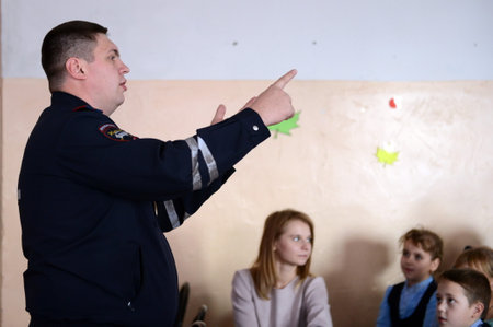 Traffic police inspector teaches traffic rules in junior schoolのeditorial素材