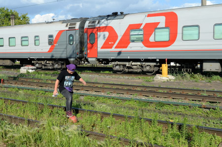Unknown boy plays with a ball on the railwayのeditorial素材