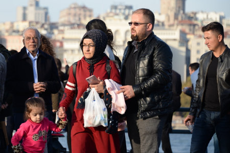 People walk on a holiday on the Galata bridge over the Golden horn Bay in Istanbulのeditorial素材