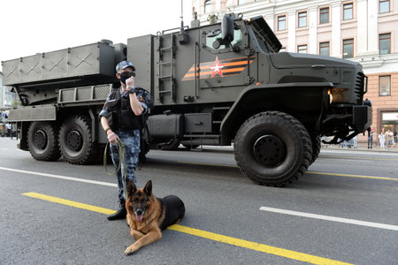 A dog handler with a service dog on public order protection during the night rehearsal of the Victory paradeのeditorial素材