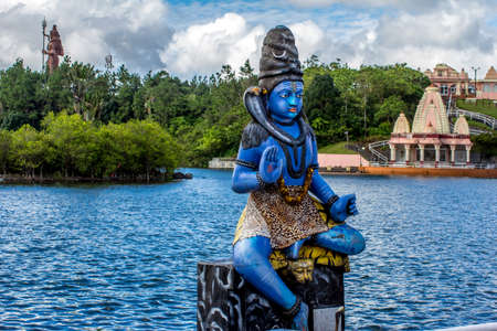 Blue Shiva statue on   the Indian temple and tropical greeneryの写真素材