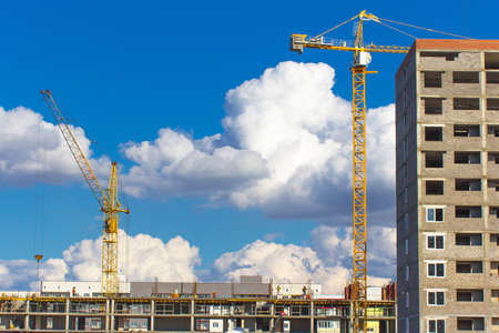 Tower cranes and construction site on the background of blue sky