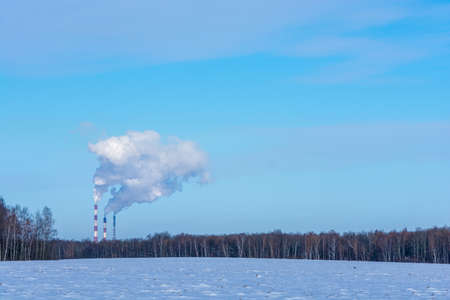 Thick smoke coming out of high pipes on the background of blue sky.の写真素材