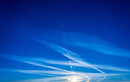 On the background of blue sky and beautiful white clouds. The sun above the horizon.の写真素材