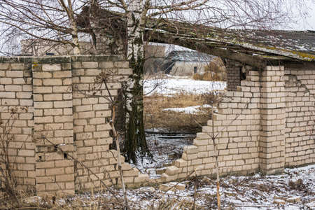 Large opening in the stone fence of white brick.