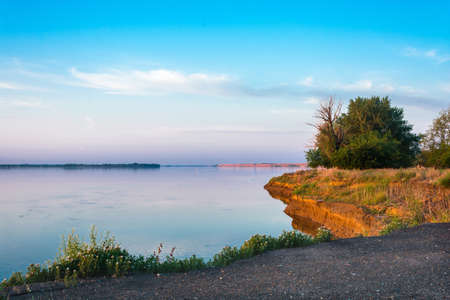 Early morning on the banks of the Volga river. Morning light beautifully illuminates the grass and trees.の写真素材