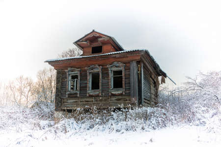 Abandoned village house on a winter background.の写真素材