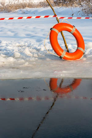 Orange lifebuoy on the edge of the great ice-hole.の写真素材