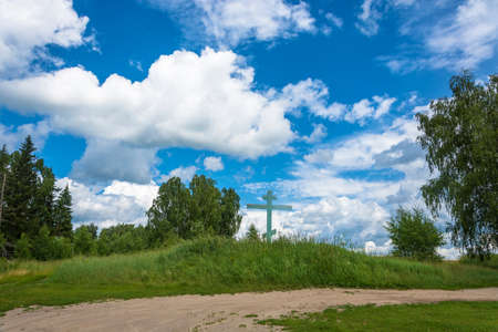 Beautiful Russian landscape with a wooden cross on a Sunny summer day.の写真素材