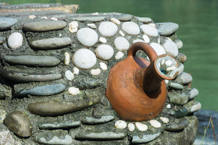 Clay jug, mounted in a wall of stone against the Blue lake, Abkhazia.の写真素材