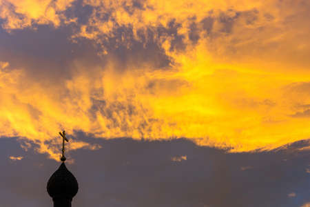 Church domes with crosses on the background of fabulously bright orange-yellow sky.の写真素材