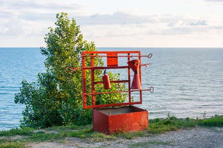 Bright red fire shield on the shore on a summer day.の写真素材