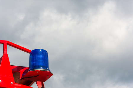 Flashing blue signal lamp, mounted on a red car.の写真素材