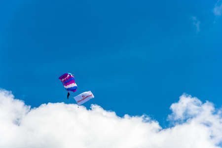 Parachutists descending on the background of beautiful cloudy sky on a Sunny day.のeditorial素材