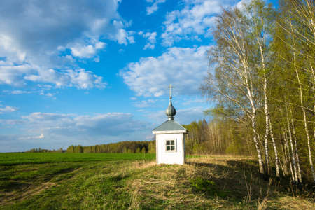 Spring landscape with a small chapel in the bright rays of the evening sun.の写真素材