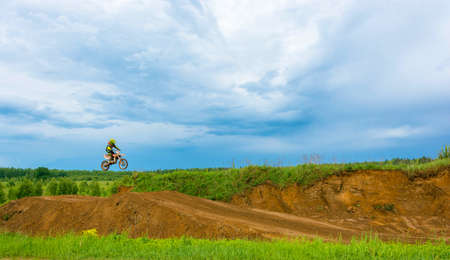 High jump the rider on the motocross track on a cloudy day.のeditorial素材