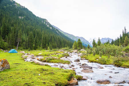 Blue tent on the Bank of mountain river in summer day, Kyrgyzstan.の写真素材