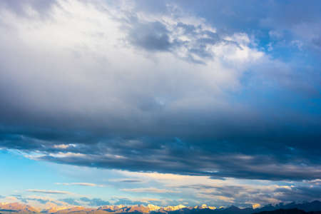 Blue sky with bright clouds, illuminated by the setting sun.