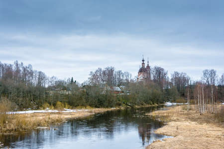 Old brick Church on the banks of a small river on a spring day. April, Russia.の写真素材