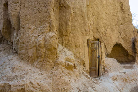 Old carved door set at the entrance to the cave and closed the locks.の写真素材