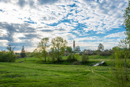 View of the village of Mikhailovskoye with views of the Church of the Holy Archangel Michael and the bodiless hosts in the rays of the setting sun.の写真素材