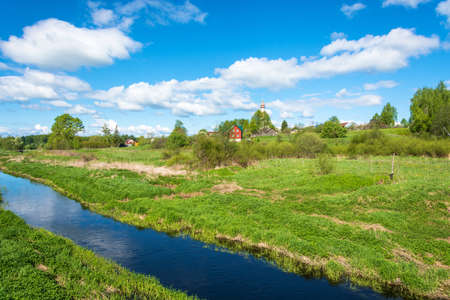 View of the village of Mikhailovskoye with views of the Church of the Holy Archangel Michael and the bodiless hosts on a Sunny spring day.の写真素材