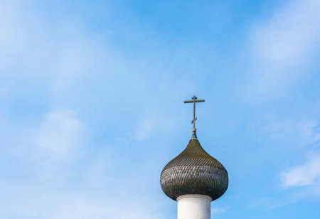 Beautiful Church dome with a cross against a blue cloudy sky.の写真素材
