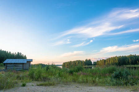 Beautiful Karelian landscape in the orange rays of the setting sun, Russia.の写真素材