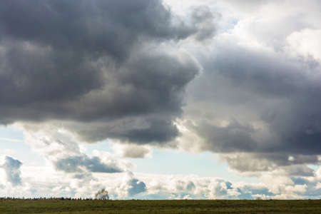 Gloomy, cloudy sky over a narrow strip of land in a autumn day.の写真素材