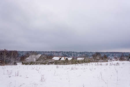 Landscape with a small village in a winter cloudy day, Russia.の写真素材
