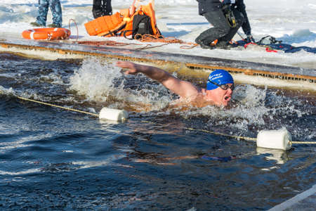 Uglich city, Yaroslavl region, Russia - 10/02/2018: Competitions in swimming in icy water, at the festival Winter fun in Uglich, 10.02.2018 in Uglich, Yaroslavl region, Russia.のeditorial素材