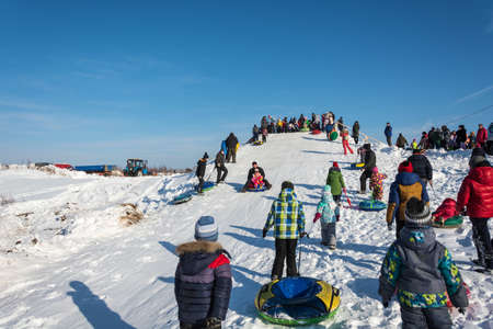 Uglich city, Yaroslavl region, Russia - 10.02.2018: Riding from the snow slide at the festival Winter fun in Uglich, 10.02.2018 in Uglich, Yaroslavl region, Russia.のeditorial素材