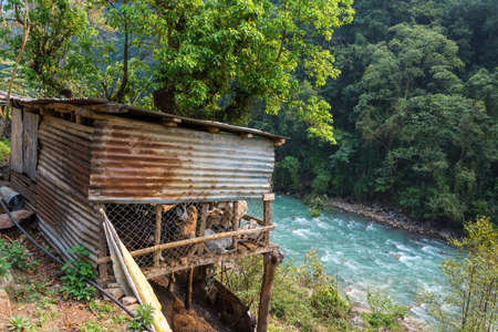Poor cattle shelter over rough mountain river, Nepal.
