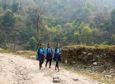 Nepal-March 28, 2018: Three cheerful Schoolgirls on a mountain road March 28, 2018 in Nepal.のeditorial素材