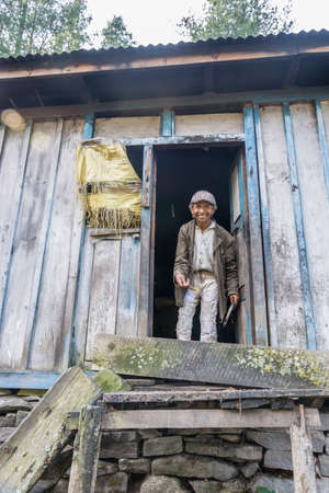 Nepal-March 30, 2018: a Smiling poor man stands at the door of his hut on March 30, 2018 in Nepal.のeditorial素材
