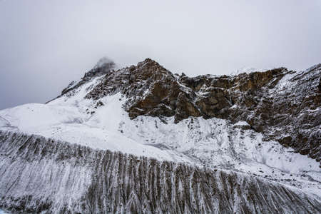 Beautiful mountain landscape on the snow-covered Thorong La pass on a cloudy day, Nepal.