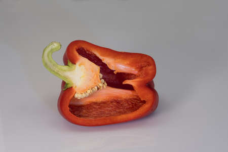 Bright red sweet pepper on a gray uniform background, close-up shot.