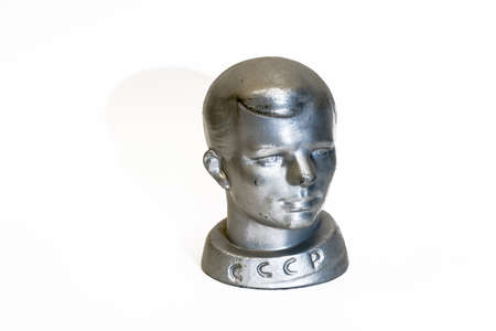 A small metal antique bust of the Soviet cosmonaut Yuri Gagarin on a white background.