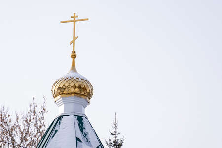 The golden dome and cross of the chapel against the sky on a winter day, Russia.の写真素材