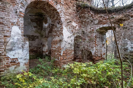 Ruins of an ancient red brick church with remnants of white plaster, Russia.の写真素材