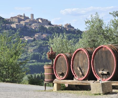 wine barrels and wine-making equipment with the town of Montepulciano in background, Italyの写真素材