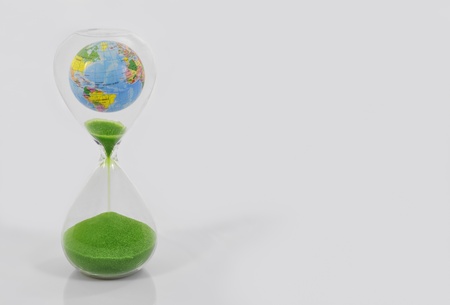 Hourglass and globe symbolizing time is running out for the environment の写真素材