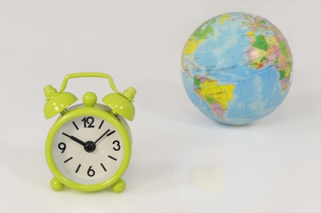Green clock and globe on white symbolizing time is running out for the environment の写真素材