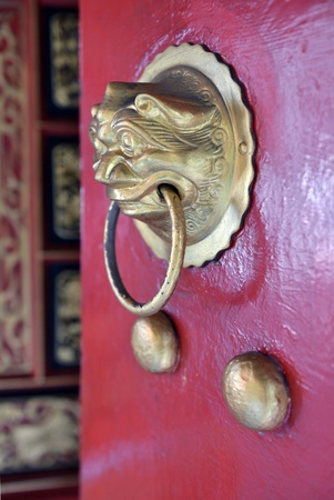 Closeup of gold decorative door knocker on red door of chinese Thean Hou temple, Penang, Malaysiaの写真素材
