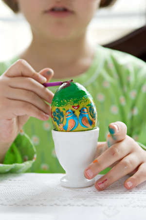 Little girl decorating easter eggの写真素材
