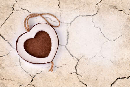 frame in wood heart shape on dry cracked earth の写真素材
