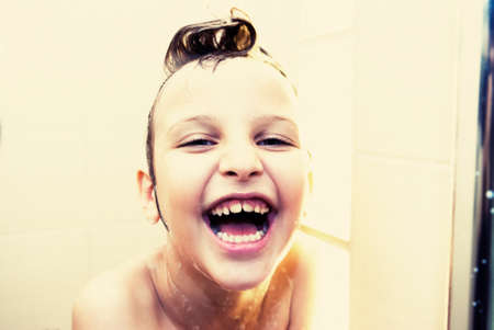 6 years old girl takes a shower in the bathroom, with a cheerful mood  Retro style の写真素材