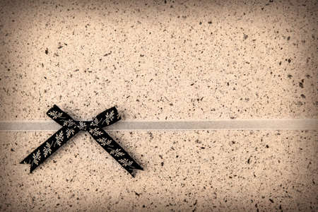 Retro ribbon and bow over real hand made paper backgroundの写真素材