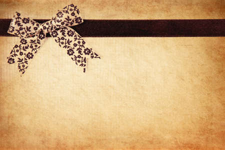 Retro ribbon and bow over real hand made paper background.の写真素材