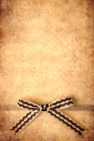 Retro ribbon and bow over real hand made paper background.の写真素材